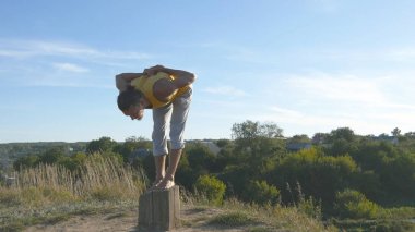 Yoga poz açık ayakta sportif delikanlı. Beyaz adam pratik Yoga hamle ve doğada konumlandırır. Tek ayak üstünde Dengeleme atlet. Güzel manzara arka plan olarak. Sağlıklı aktif yaşam tarzı