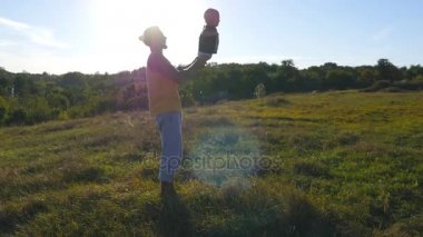 Doğa onun çocuğuna oynayan genç baba. Baba oğlu holding bacaklar ve açık atar. Mutlu bir aile birlikte dışarıda çayır vakit. Arka plan, güzel manzara. Yakın çekim
