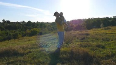 Genç baba oğlunun hava içine atma ve onu eline açık yakalamak. Doğa onun çocuğuna oynama baba. Mutlu bir aile birlikte dışarıda çayır vakit. Güzel arka plan