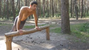 Gönderme yapan atletik erkek ups orman günlüğünden. Yaz aylarında wood adlı açık eğitim güçlü genç kas adam. Atlet güzel doğa egzersiz. Egzersiz sağlıklı yaşam tarzı. Yakın çekim