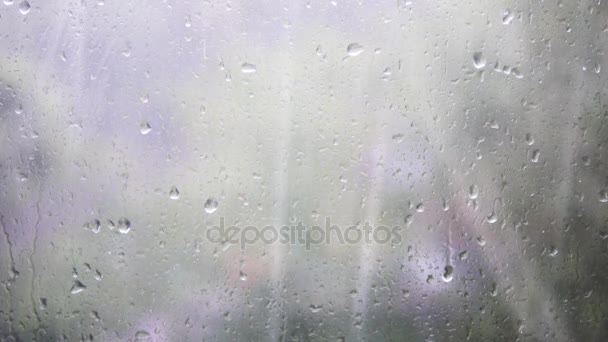 Detail z kapky vody na skle. Kapky deště na okenní sklo s rozostření pozadí. Rozmazané strom a obloha. Deštivé dny, déšť stékající okno, bokeh