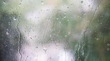 Yakın çekim cam üzerinde Su damlacıkları. Görüntü arka plan ile pencere camına yağmur damlaları. Bulanık ağaç ve gökyüzü. Yağmurlu günler, camı, bokeh çalıştıran yağmur