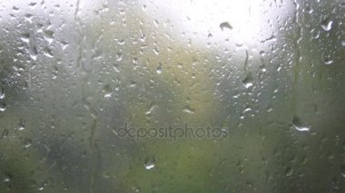 Yakın çekim cam üzerinde Su damlacıkları. Görüntü arka plan ile pencere camına yağmur damlaları. Bulanık ağaç ve gökyüzü. Yağmurlu günler, camı, bokeh çalıştıran yağmur