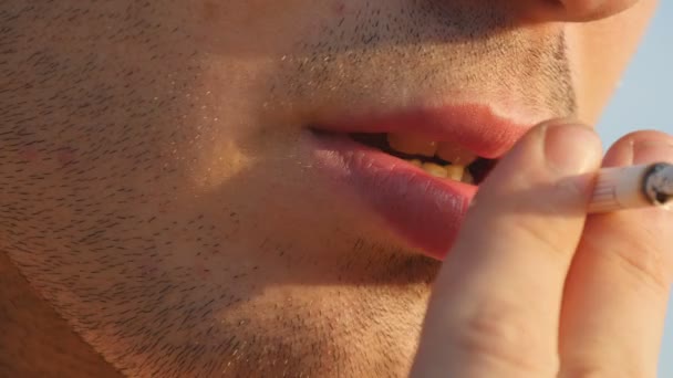 Close up of young man mouth smoking cigarette, smoke inhale, bad habit, drugs. Male mouth blowing smoke outdoor — Stock Video
