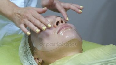 Güzellik Salonu bir güzel kız yüz yüz maskesi uygulayarak Şevval Özçelik Güzellik. Bir yüz bakım sahip bir kadın. Yüz maskeleri kozmetik kullanımı. Genç bir kadının yüzünde maske silikon ile yakın çekim