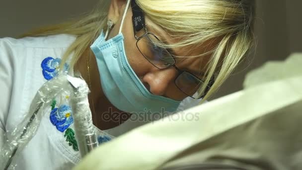 Ritratto ravvicinato di medico donna in occhiali con usura protettiva da lavoro. Viso femminile in maschera medica. Cosmetologo o terapeuta sta lavorando — Video Stock