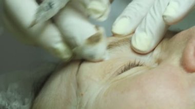 Elinde Şevval Özçelik Güzellik cilt yordamı için hazırlanıyor veya işlemden sonra temizlik. Yaşlı kadın yalan ve Başlarken kirpik makyaj Güzellik Salonu. Kalıcı hale kirpik üzerinde uygulanması.