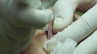 Yaşlı kadın yalan ve Başlarken kirpik makyaj Güzellik Salonu. Kalıcı hale kirpik üzerinde uygulanması. Kalıcı makyaj kirpik yapma güzellik uzmanı. Kaşları ile ana çalışır. Yarı kalıcı makyaj