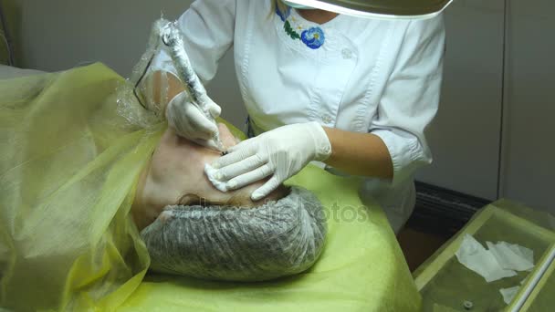 Wanita tua berbohong dan mendapatkan riasan bulu mata di salon kecantikan. Menerapkan Permanen Make up pada bulu mata. Beautician membuat riasan permanen dari bulu mata. Master bekerja dengan alis mata. Riasan semi-permanen — Stok Video