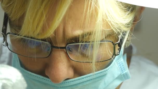 Primer plano retrato de doctora en gafas con ropa de trabajo protectora. Cara de mujer con máscara médica. Cosmetólogo o terapeuta está trabajando — Vídeo de stock