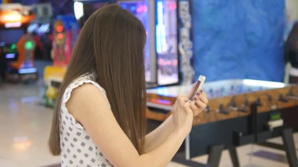 Mladá žena hraje vnitřní na shopping center, pomocí chytrého telefonu. Dívka hraje populární smartphone - chytání Pokémon v hypermarketu mall — Stock video