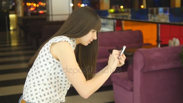 Mujer joven jugando al interior en el centro comercial, usando un teléfono inteligente. Chica jugar el popular juego de teléfonos inteligentes - la captura de pokemon en el centro comercial hipermercado — Vídeos de Stock