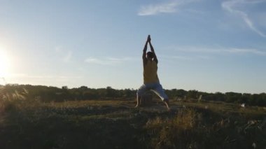 Yoga poz açık ayakta sportif delikanlı. Beyaz adam pratik Yoga hamle ve doğada konumlandırır. Dengeleme atlet. Güzel manzara arka plan olarak. Sağlıklı aktif yaşam tarzı