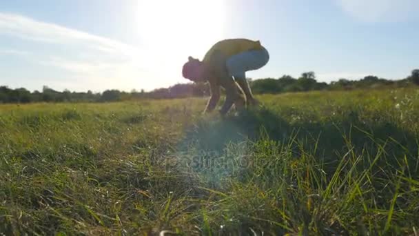 Спортивний юнак практикуючих стійку йога поза в природі. Кавказький хлопець роблять йоги рухається, так і на відкритому повітрі. Красивий ландшафт і небо у фоновому режимі. Здорового активного способу життя. Крупним планом — стокове відео