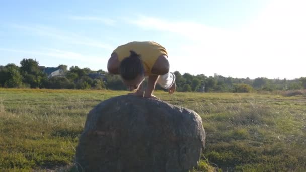 Jeune homme sportif pratiquant la pose avancée difficile de yoga à la nature. Homme caucasien faisant des mouvements de yoga et des positions à l'extérieur. Beau paysage en arrière-plan. Mode de vie sain et actif. Gros plan — Video