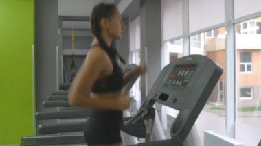Güçlü olan kadın spor salonunda koşu bandı üzerinde çalışan mükemmel fitness vücutta. Kardiyo egzersiz sırasında egzersiz kız. Erkek Spor Kulübü'nde kapalı eğitim. Koşu insanlar. Yakın çekim