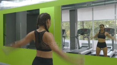 Spor salonunda ayna önünde eğitim genç fitness kadın. Kadın atlet vücudu ve eller önce egzersiz germe. Kız egzersiz sağlık kulübü. Yakın çekim