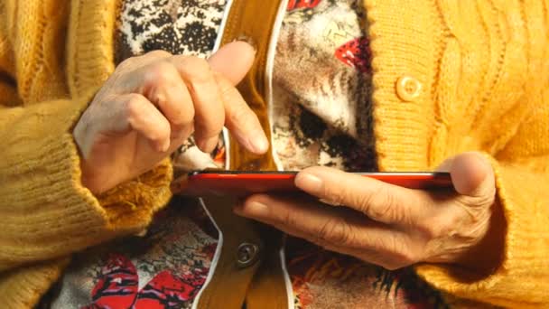 Handen van de oude vrouw en de smartphone. Close-up — Stockvideo