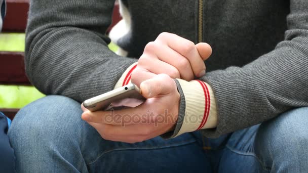 彼の手でスマート フォンを持つ男は、別の人と身振りで示すことに何かを示しています. — ストック動画
