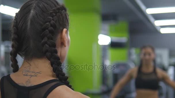 Junge hübsche Frau trainiert im Fitnessstudio vor dem Spiegel Hanteln heben und senken. Sport Fitness Mädchen, das mit Gewichten trainiert und an Muskeln arbeitet. Nahaufnahme. Gesunder aktiver Lebensstil — Stockvideo