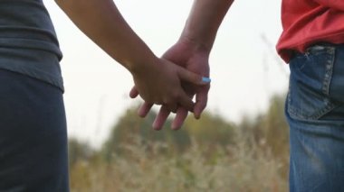 Genç çift katılmadan açık eller. Doğa arka plan üzerinde silah alarak kadın ve erkek. Rahatlatıcı ve birbirlerine okşayarak erkek ve dişi eller. Sevgi ve bağlılık sembolü. Romantik dışarıda. Yakın çekim