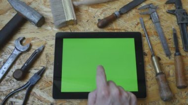 Erkek el ile atölye Yeşil perde tablet pc kullanarak esnaf usta. Üstten Görünüm. Yanında farklı vintage araçları yalan