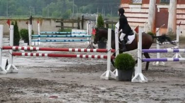 Profesyonel kadın jokey at sırtında sürmek. At dört nala gidiyorum ve yarışmada bir engel üzerinden atlama
