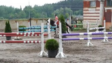Profesyonel kadın jokey at sırtında sürmek. At dört nala gidiyorum ve yarışmada bir engel üzerinden atlama