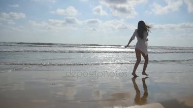 Mutlu kadın çalışan ve iplik sahilde okyanus yakın. Genç güzel kız hayattan zevk ve deniz sahilinde eğleniyor. Yaz tatili ya da tatil. Arka plan, doğa manzara. Ağır çekim