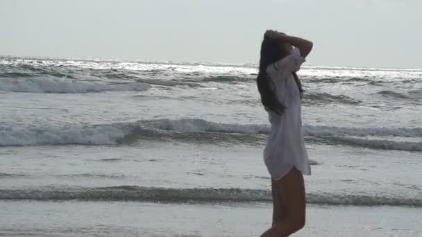 Mujer feliz caminando y jugando en la playa cerca del océano. Joven hermosa chica disfrutando de la vida y divertirse en la orilla del mar. Vacaciones de verano o vacaciones. Paisaje exótico de fondo. Movimiento lento — Vídeos de Stock