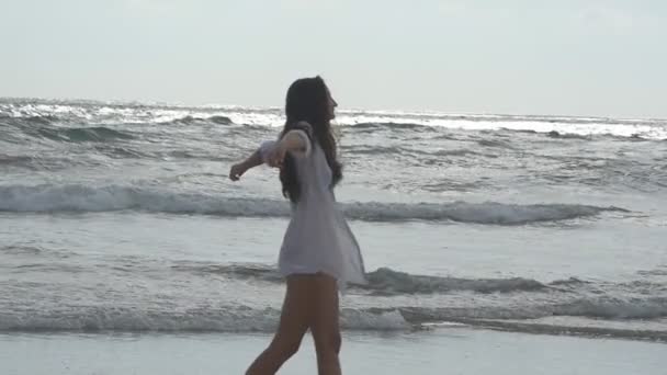 Mujer feliz caminando y jugando en la playa cerca del océano. Joven hermosa chica disfrutando de la vida y divertirse en la orilla del mar. Vacaciones de verano o vacaciones. Naturaleza paisaje en el fondo. Movimiento lento — Vídeos de Stock