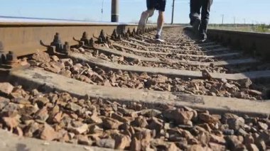 İki adam arasında demiryolu parça on rails çalıştırıyorsunuz. Yataklı vagonlar üzerinde koşu koşu runner çocuklar. Bacaklar yaz açık eğitim spor sporcu. Aktif sağlıklı yaşam tarzı dışında. Yakın çekim