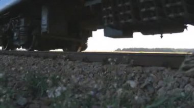 Yolcu treni bir kamera tarafından geçer. Tren rayları closeup hareketli tekerlekleri. Bir yolcu yakın çekim çekim tarafından geçen tren. Rahat tren ile seyahat.