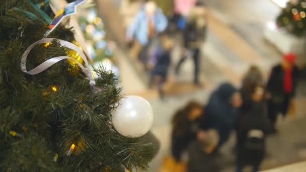 Karácsonyi játékok, a háttérben a homályos emberek séta a bevásárló központ új év Eve. Téli ünnepi vásárlási fogalmának. Szemközti nézet — Stock videók