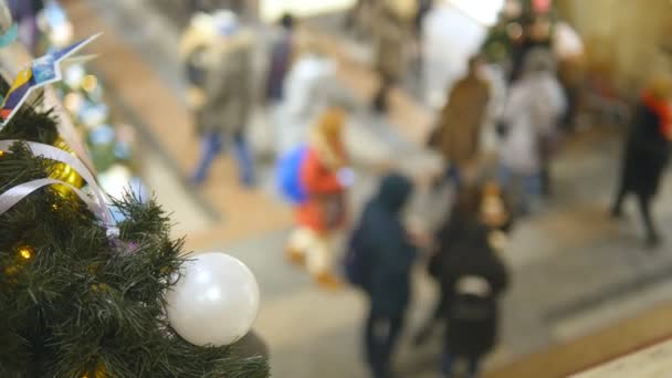 Juguetes de Navidad en el fondo de personas borrosas caminando en el centro comercial en la víspera de Año Nuevo. Concepto de compras de vacaciones de invierno. Vista superior — Vídeos de Stock