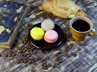 Siyah kahve ve antika arka plan üzerinde renkli macarone