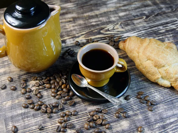 Kaffee und Croissant auf Holztisch. — Stockfoto
