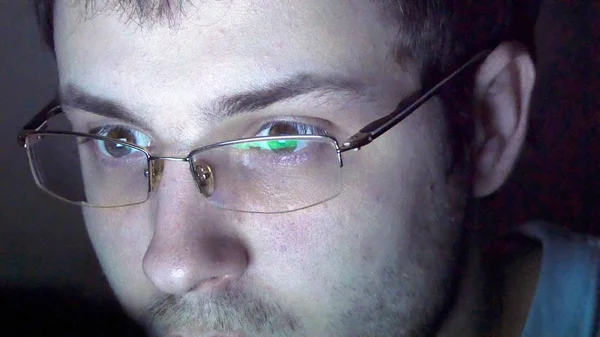 Nahaufnahme eines Mannes mit Brille, der nachts im Internet surft — Stockfoto