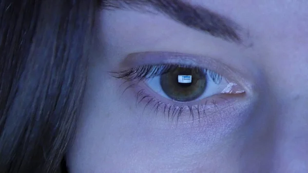 Close up di ragazze occhio lettura internet, con riflesso dello schermo nel suo occhio di notte — Foto Stock
