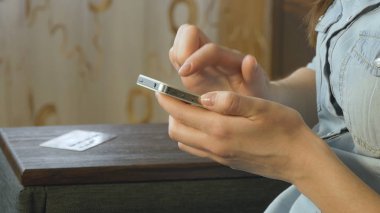 Akıllı telefon kullanan genç bir kadın.