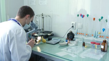 Mikroskop ile ilgilenen genç erkek doktor