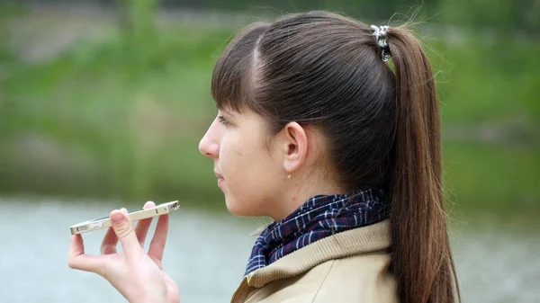 Mädchen sprechen im Frühling auf dem Smartphone im Freien. Nahaufnahme — Stockfoto