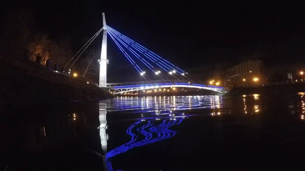 Brücke mit Lichtern, die sich nachts im Wasser spiegeln — Stockfoto