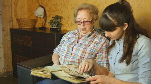 Mulher velha e jovem olhando para o álbum de fotos da família — Fotografia de Stock