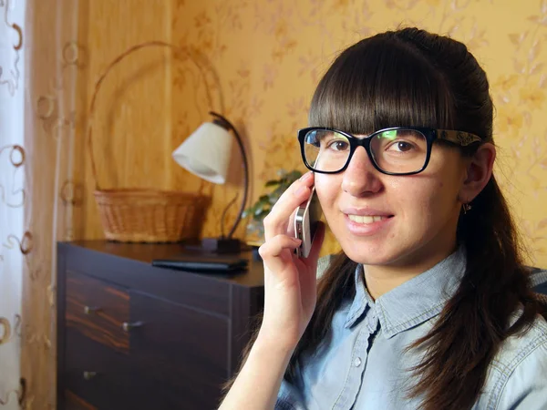 Vidám fiatal nő beszél mobilon otthon — Stock Fotó