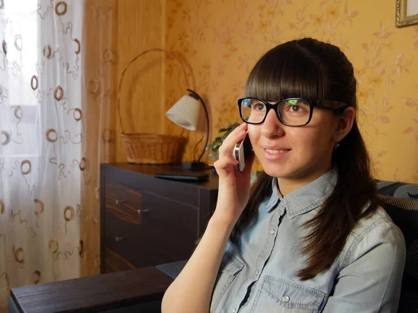 Vidám fiatal nő beszél mobilon otthon — Stock Fotó