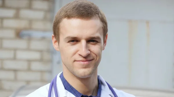 Ritratto di giovane medico caucasico sorridente all'aperto — Foto Stock
