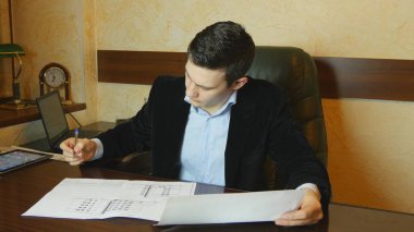 Genç işadamı masasında Office belgeleriyle çalışma