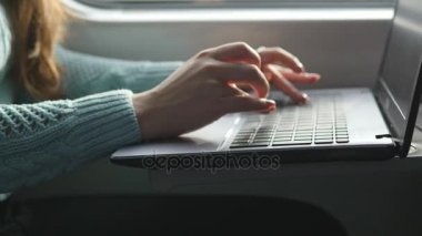Tren içinde laptop klavye yazarak eller. Kadın demiryoluna seyahat sırasında arkadaşlarınızla sohbet. Dizüstü bilgisayar kullanan genç kız. Kol bir ileti yazdırır. Yakın çekim