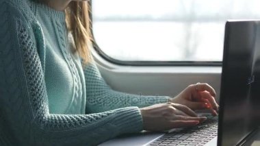 Tren içinde laptop klavye yazarak eller. Kadın demiryoluna seyahat sırasında arkadaşlarınızla sohbet. Dizüstü bilgisayar kullanan genç kız. Kol bir ileti yazdırır. Yakın çekim